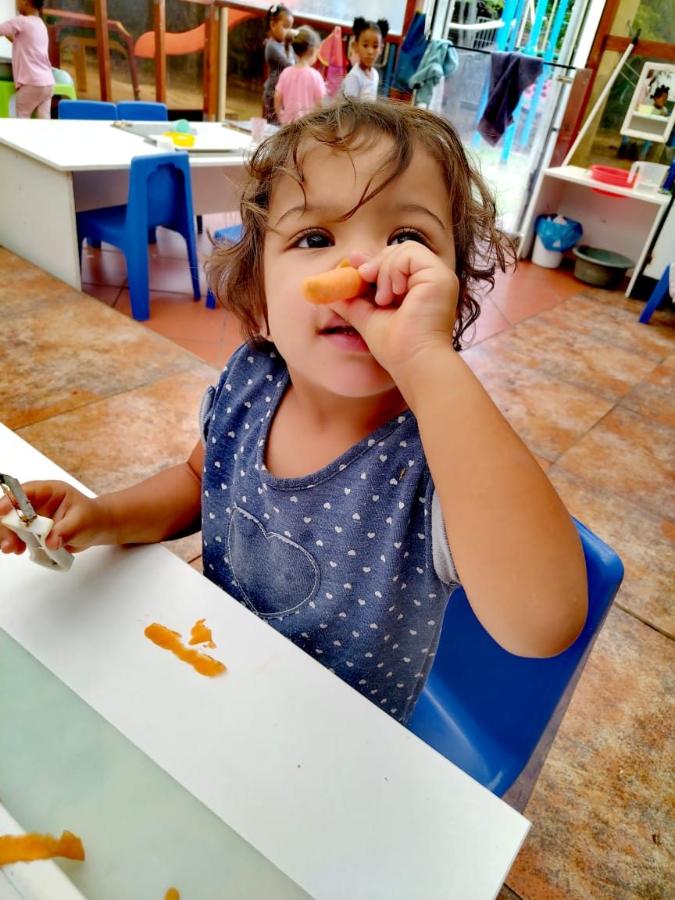Toddler giggling with a carrot