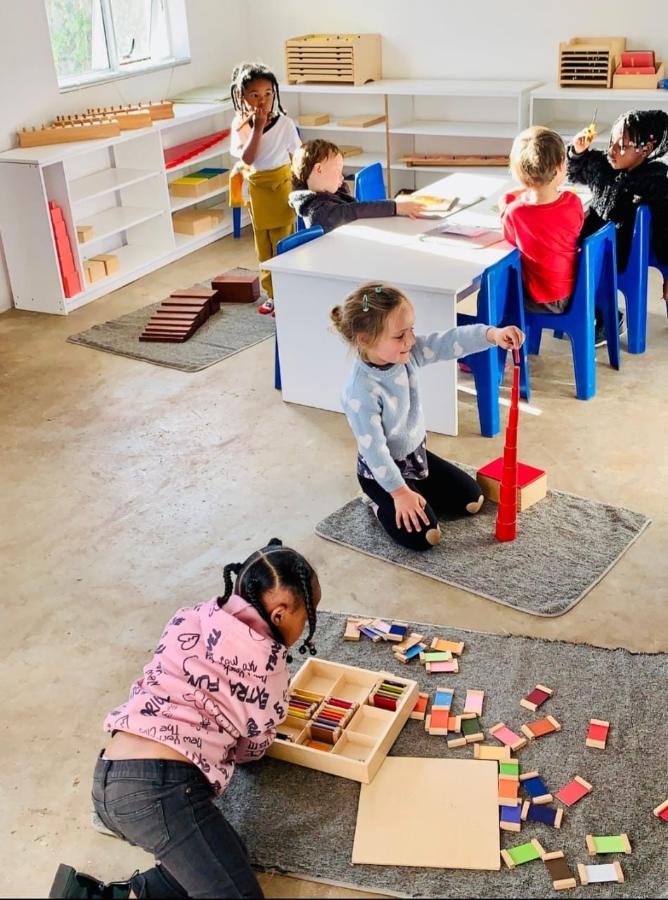 Girl in pink working with Montessori colour tablets